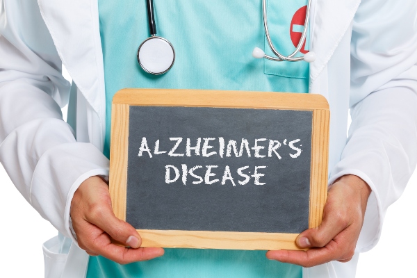 A doctor holds a sign that reads Alzheimer's Disease on it.