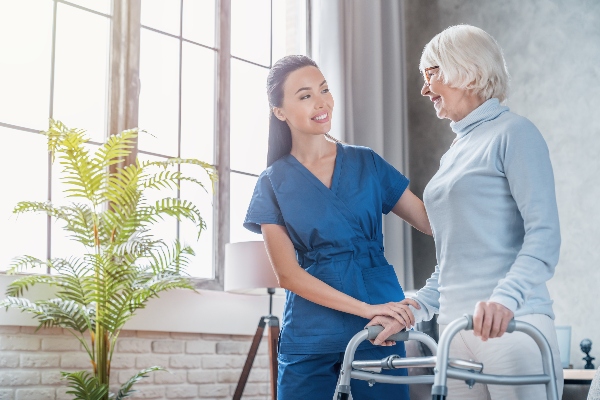 A home health care nurse provides needed help to an elderly lady.