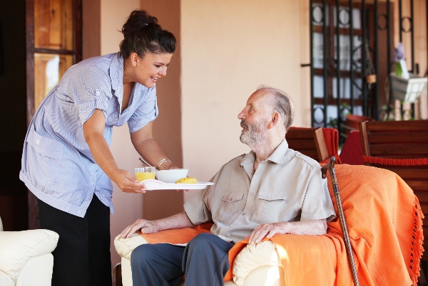 An in-home caregiver gives a senior the help he needs.