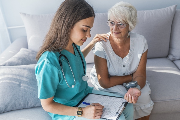 A private duty home caregiver helps out a senior at their home.